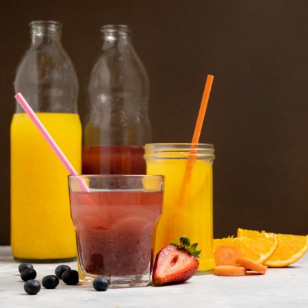 Copos de refrigerante e suco adoçado, representando o consumo diário que eleva o risco hepático.